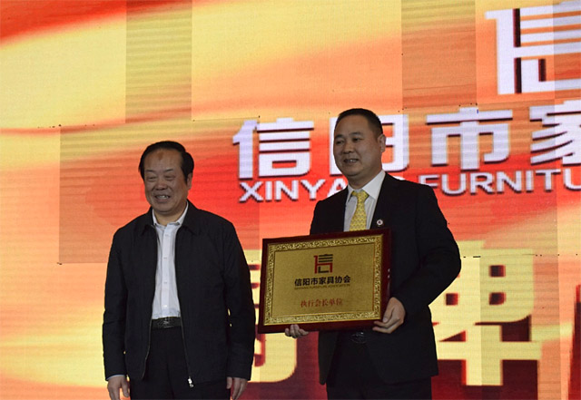 信阳市副市长包盛柏(左)为程一董事长颁发家具协会会长证书